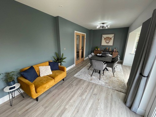 An open plan kitchen with a yellow couch and a table
