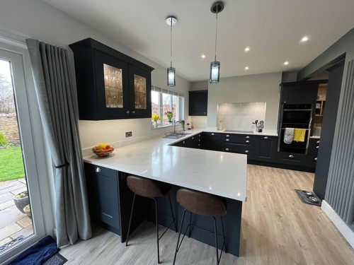 A blue Shaker kitchen with a white worktop