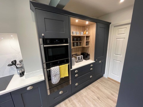 A blue shaker kitchen with built-in ovens