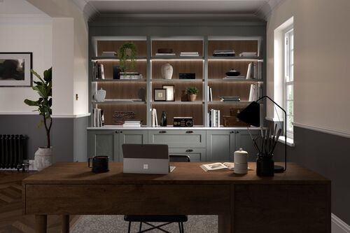 A wooden desk in a room with shelves and a computer