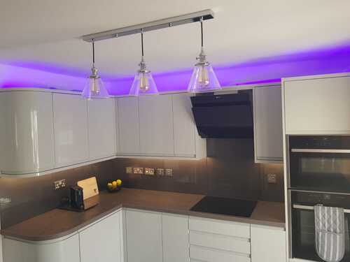 White kitchen with purple LED lighting and glass pendant lights