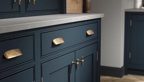 Navy cabinet detail with brass cup handles and hardware