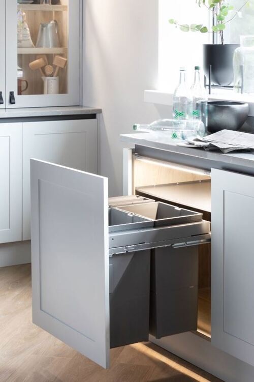 Pull-out waste bin system in white kitchen cabinet