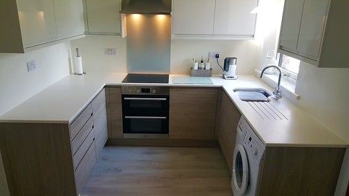 Small U-shaped kitchen with wood-effect units and integrated appliances