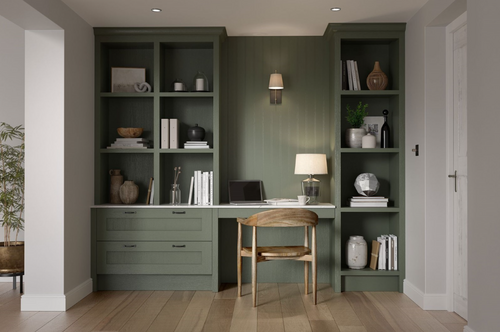 Built-in sage green office with wooden chair and open shelving