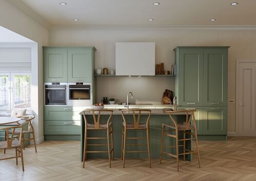 Sage green kitchen with wooden bar stools and herringbone flooring