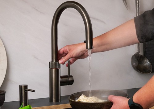 kitchen tap with hand using pull-down spray feature