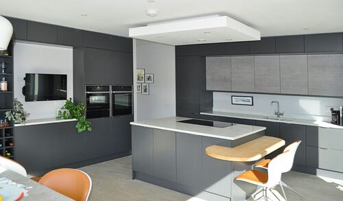 Modern grey kitchen with white countertops and large windows