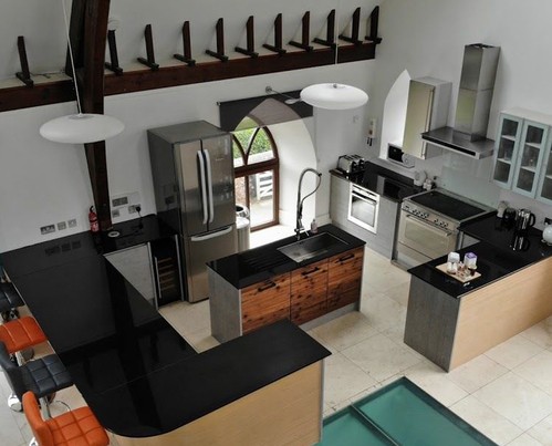 White kitchen cabinets with wooden countertops and grey tile backsplash