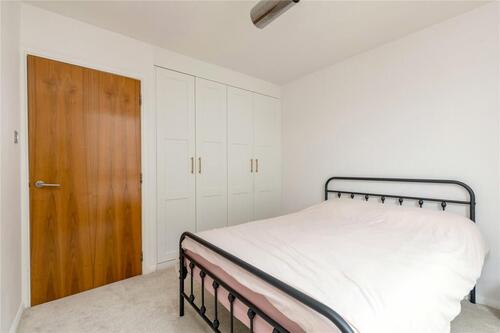 Built-in white wardrobe and storage solutions in modern bedroom