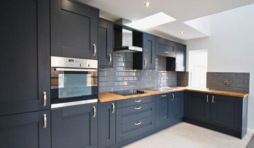 Modern grey kitchen with white countertops and large windows