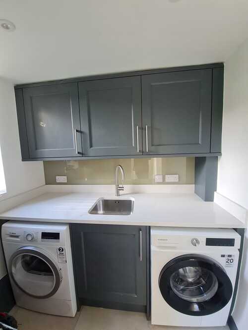 Stylish utility room with grey cabinets and dual laundry appliances