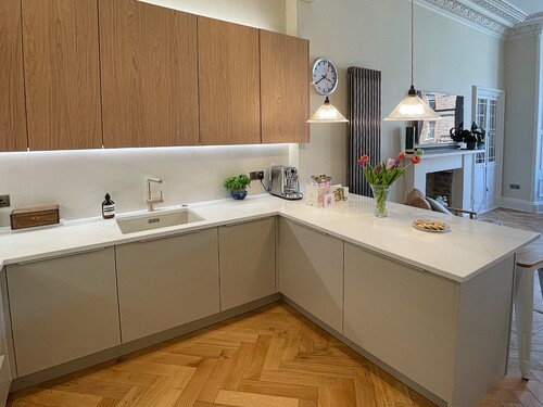 Modern L-shaped kitchen with wood splashback and lighting