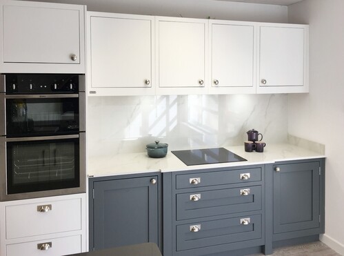 Modern kitchen display with white and navy cabinets and built-in appliances