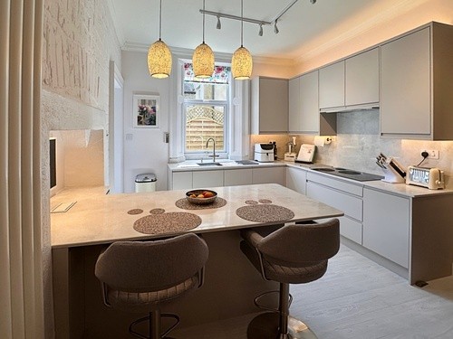 black fitted kitchen with orange splashback