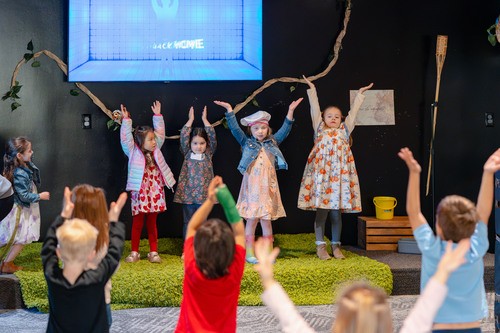 children raising their hands during worship time