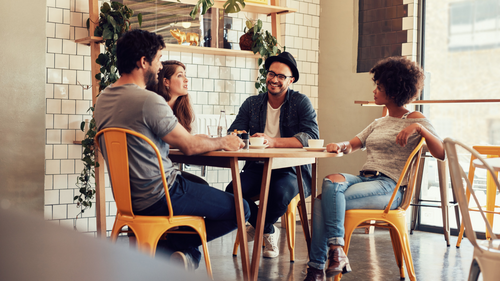 Faded image of people sitting at a table talking.