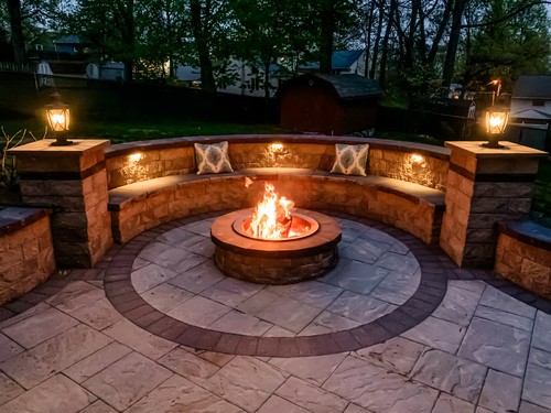 Outdoor living space with marble inlay fire pit area and pillars in Pompton Lakes NJ
