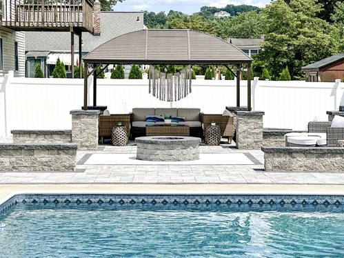 Custom paver courtyard with fire pit, seating walls, and gazebo lounge in Pompton Lakes NJ