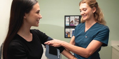 female medical assistant taking blood pressure of female patient