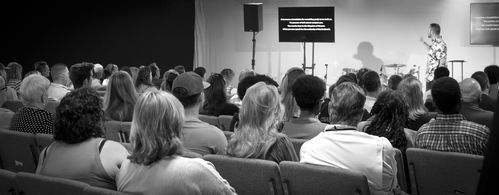 Champion Church congregation during a church sermon with two screens displaying church lesson.