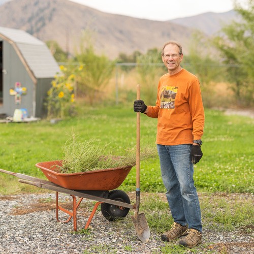 Man with wheelbarrow and shovel doing yard cleanup