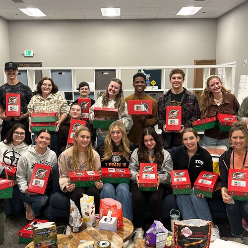 Students holding Shine encouragement package boxes