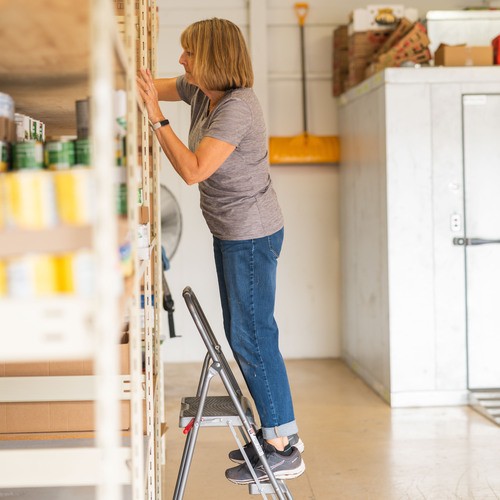 Volunteer organizing shelves at the Cashmere Food Bank