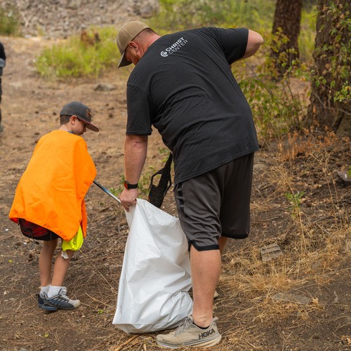 Man and boy picking up trash bags in Hay Canyon