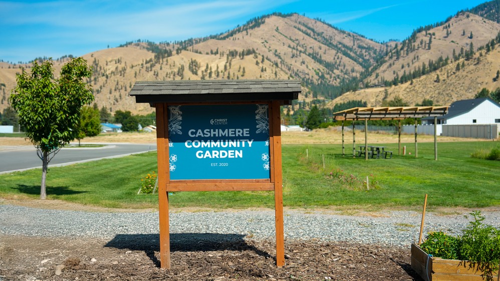 The Cashmere Community Garden sign with the hills behind it