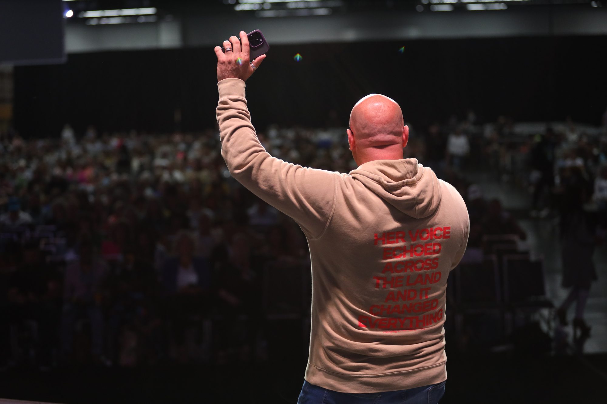 A packed arena of people at a conference
