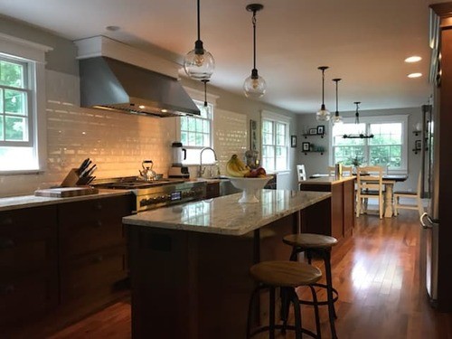 Modern kitchen featuring a white subway tile backsplash, sleek cabinetry, stainless steel appliances, and granite countertops with subway tile backsplash