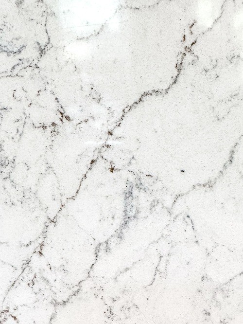 Close-up of a quartz surface with a white background and subtle grey veining.