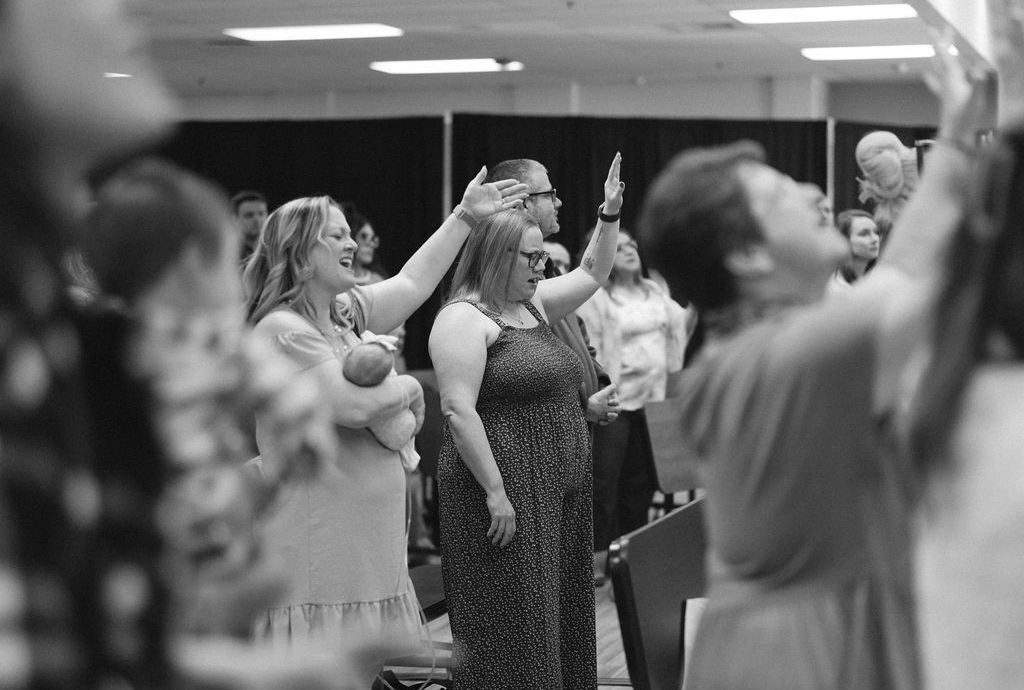 A community gathered together with arms around one another