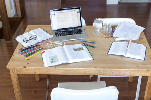 Table With Laptop, Bible, NoteBook, Pens and Other Study Materials.
