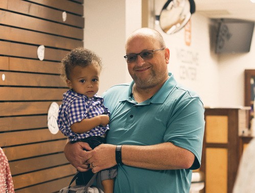 UHBC member holding a baby at the welcome center of University Heights Baptist Church in Stillwater, OK