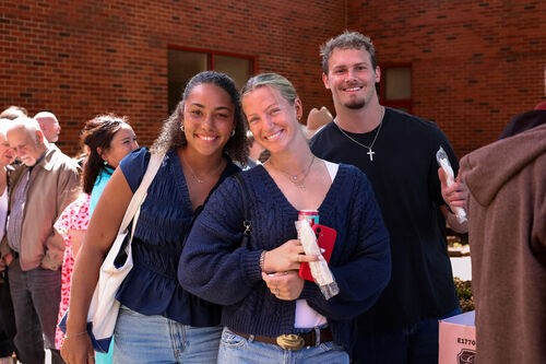 UHBC college students waving and smiling at a University Ministry event in Stillwater, Oklahoma