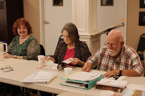 Two UHBC senior women smiling and listening during a class at University Heights Baptist Church in Stillwater, Oklahoma