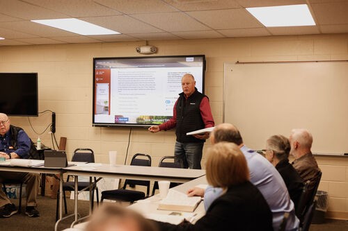 UHBC senior adult man reading Scripture on a tablet at a Bible study class in Stillwater, Oklahoma