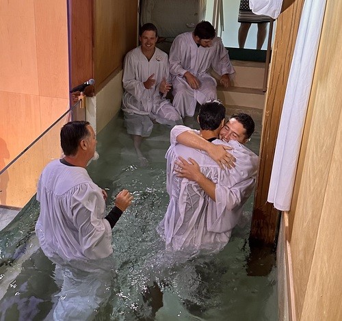 UHBC member being baptized and embraced in the church baptistry at University Heights Baptist Church in Stillwater, Oklahoma