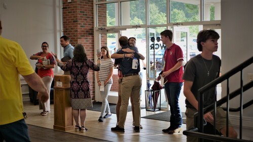 Wake Cross Roads Baptist Church welcomes you! Photo shows happy people welcoming each other in the church lobby.