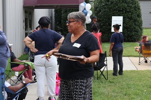A Cornerstone Cares volunteer welcomes neighbors outside Shepherd&rsquo;s Hall