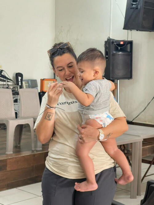 Sara playing with a little boy in her arm Sara与她怀中的小男孩玩