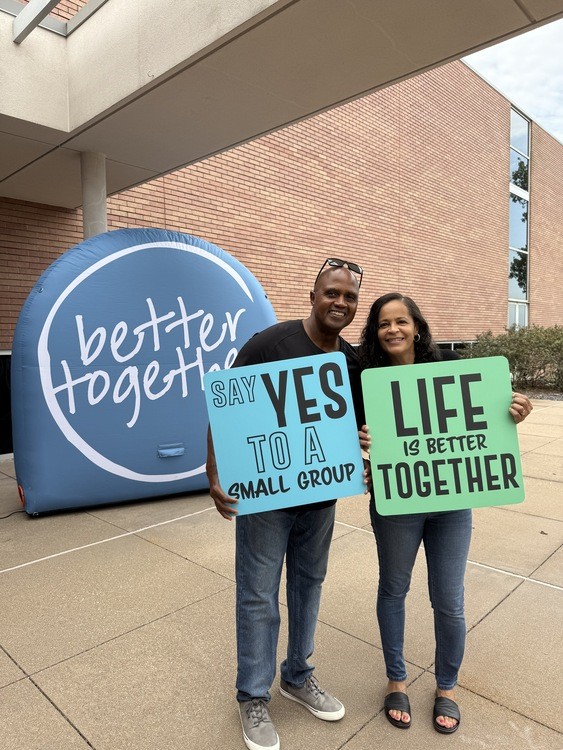 A couple holding small group signs at The Bridge