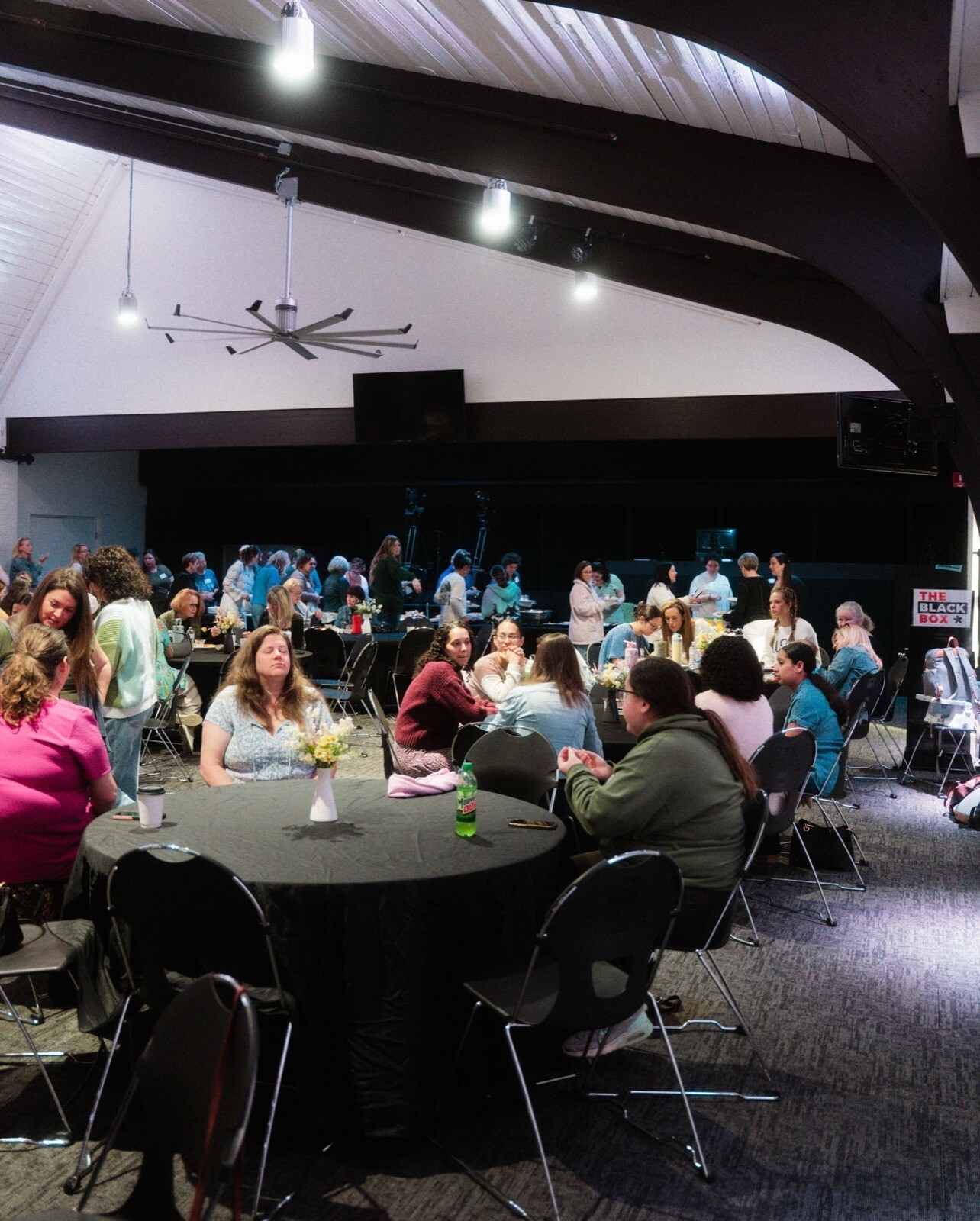 A bright room full of women at round tables