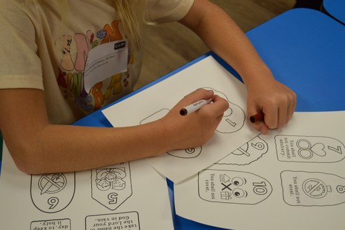 A fourth grader colors the 10 Commandments during Sunday school