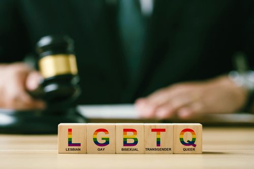 Concept of Lgbt rights and law. wooden blocks with Text LGBTQ on Judge gavel background. symbol of law and justice in accepting same-sex couples Same-Sex Marriage, Adoption, and Social Equality.