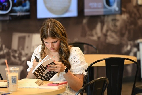 Visitor reading Foundations book in The Cove.