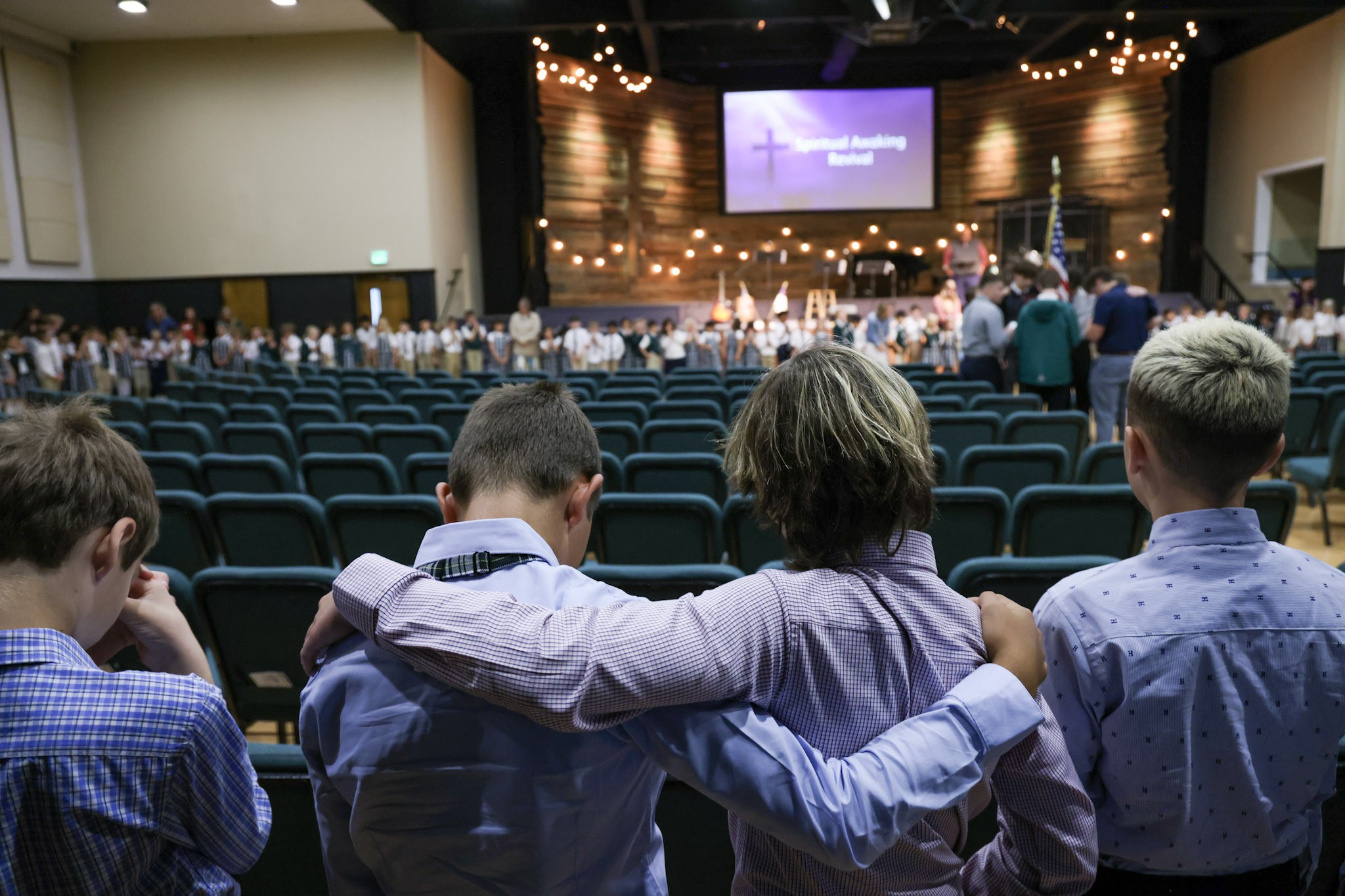 Heritage students supporting one another in prayer during chapel