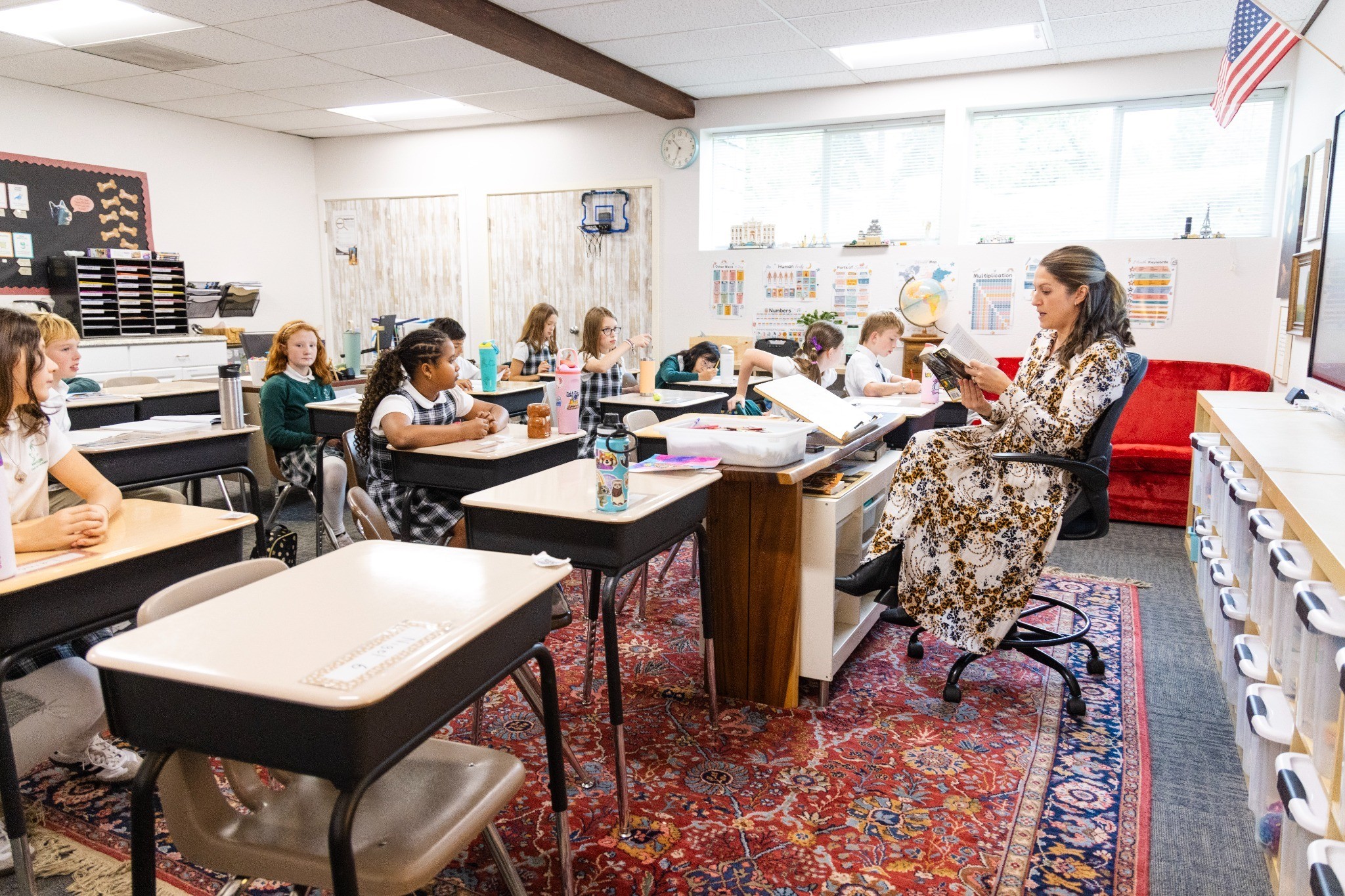 Elementary students listening as their teacher reads aloud in the classroom